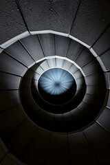 Obraz premium Low angle view of spiral staircase ascending into blue light