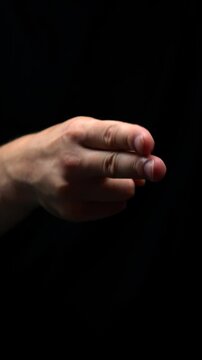 Man imitates scissors with fingers on hand.
Scissors gesture close-up on black background.
Man plays game and shows scissors with hands