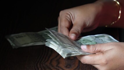 Business women counting Indian 500 Rupee banknotes