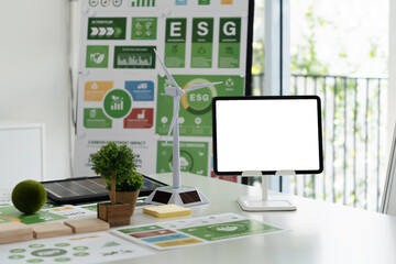 A diverse business team analyzing environmental charts and graphs in a collaborative meeting to create sustainable strategies in a modern office.