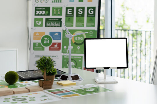 A diverse business team analyzing environmental charts and graphs in a collaborative meeting to create sustainable strategies in a modern office. - Powered by Adobe