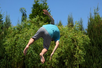 A Young Boy Diving into a Pool that is Surrounded by Beautiful, Lush Greenery and Nature