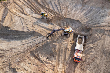 aerial view of quarry. excavator loading sand into dump truck