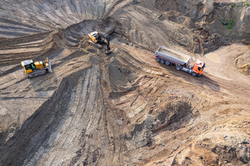 aerial view of quarry. excavator loading sand into dump truck