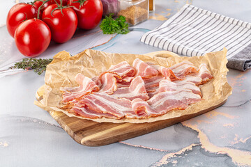 Sliced pork bacon over board