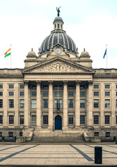 Fototapeta premium Majestic neoclassical building with a grand dome and imposing columns stands proudly in a wide open plaza under a bright sky