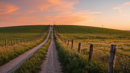 Sunset casts warm light over a green hill and its traversing country road.
