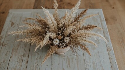 Obraz premium Dried botanicals displayed in a ceramic dish atop a rustic painted wooden surface