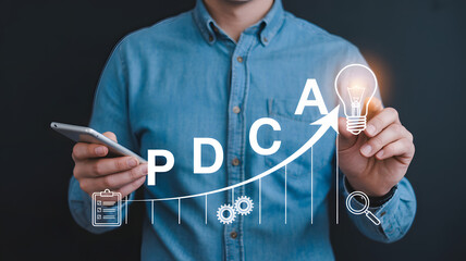 Man uses tablet to analyze PDCA cycle for business improvement and innovation with upward trend graph