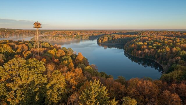Spectacular overhead shot of karst water bodies and viewing tower in bright autumn sunlight
