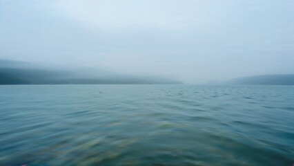 Fototapeta premium Abstract seascape in shades of blue, grey, and green captured with slow shutter panning.