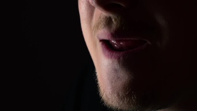 Whistle sign on a black background.
Male whistling lips in a dark space.
imitation of whistling and development of orticulation and speech.
Clear and correct speech