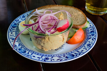 Obatzda, Obazda or Obatzter Bavarian Cheese Spread Garnished with Onions in a Bowl and Bread Close Up