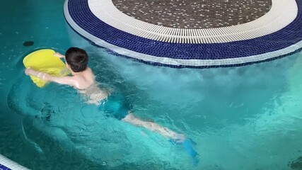 Boy Practicing Swimming with Kickboard in Pool