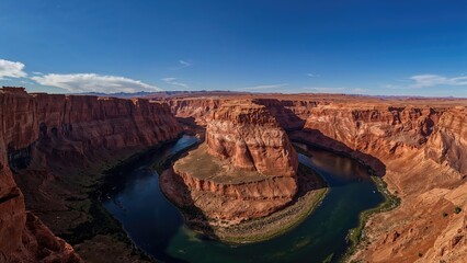 Long-range view of the river's curved trail in a canyon, basking in bright daylight.