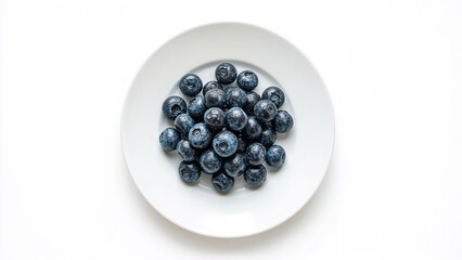 Blueberries in focus on a white plate, isolated against white, summer diet fruit