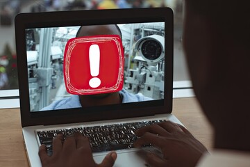 Laptop screen displaying a security alert with a red exclamation mark over a person's face, in front of a blurred background of urban environments
