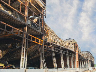 A severely damaged building shows the aftermath of a destructive fire, with visible structural damage.