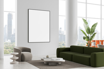 Modern interior with framed blank poster on clean wall in luxury living room featuring green sofa, gray armchair and city view through large windows. 3D Rendering