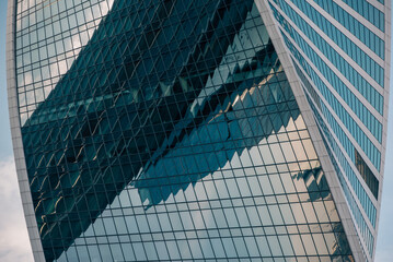 Fototapeta premium mirrored windows of the facade of an office building with blue panels