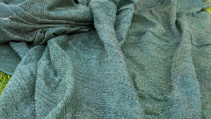 Fototapeta premium Draped in verdant knitted whispers, the fabric tells tales of Hygge warmth and World Textile Day marvels
