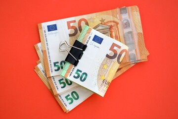 Big amount of european euro currency money notes on red color table close up