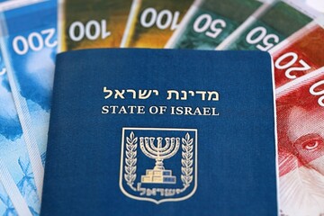 Israel New Shekels banknotes and passport on flag. The current Israel money bills and pass