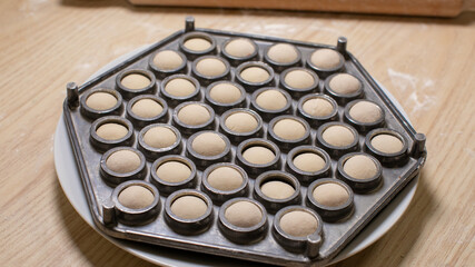 Hexagonal dumpling mold brimming with doughy potential, resonating with Lunar New Year culinary magic and Slavic dumpling traditions