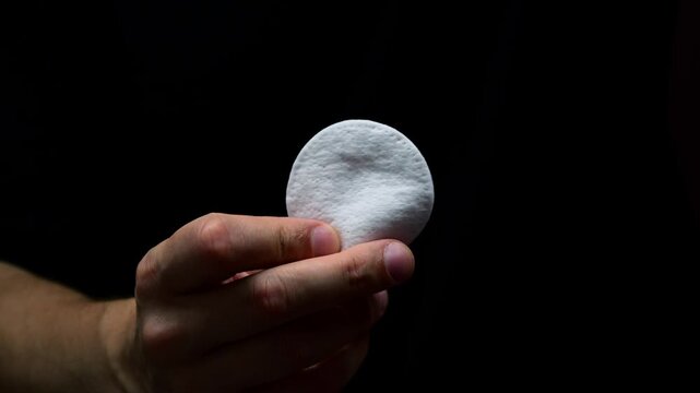 Round sponge for applying cosmetics or medicine.
Medical cotton pad on black background close-up.
Man holding cotton pad in hands