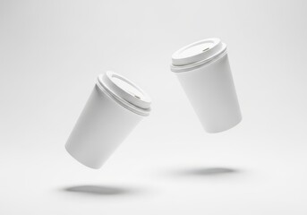 Two white takeaway coffee cups floating