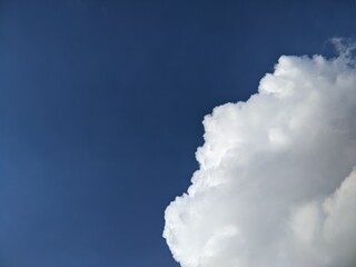 Bright blue sky with fluffy white cloud

