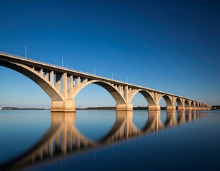Fototapeta premium Stunning view of the Confederation Bridge against a blue sky with water reflection