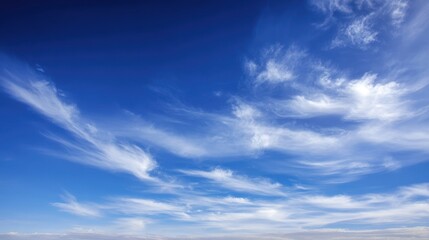 The serene beauty of a clear blue sky with wispy clouds.