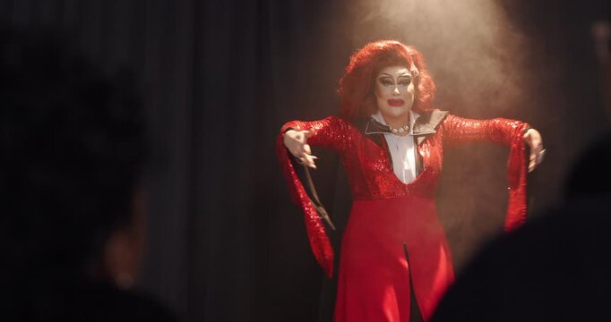 Dark, sing and smoke with drag artist on stage for expression showcase or theater performance. Concert, dance and spotlight with lgbtq performer in auditorium for energy, event or individuality