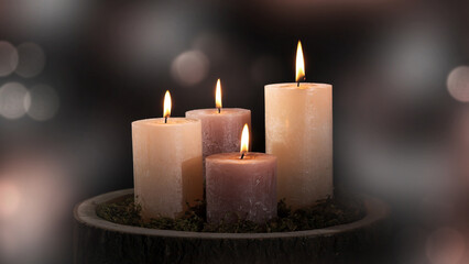 four burning wax candles for decoration isolated on blurred abstract background with defocused bokeh light