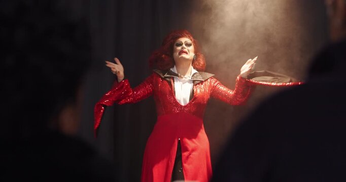 Showcase, singer and stage with drag performer in theater for LGBT culture, nightlife and spotlight. Identity, entertainment and music with person singing at event for talent, audience and pride