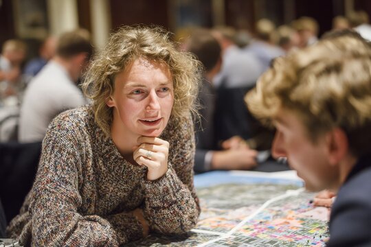 Engaging discussion between individuals at a networking event focused on city planning and urban development