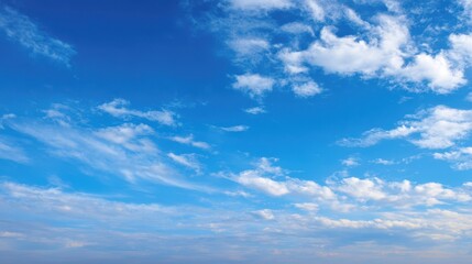 Fototapeta premium The serene blue sky with scattered fluffy clouds above the horizon.