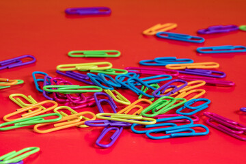 Clips fluorescentes de colores sobre fondo rojo