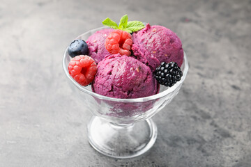 Delicious sorbet with fresh berries and mint in dessert bowl on grey textured table, closeup