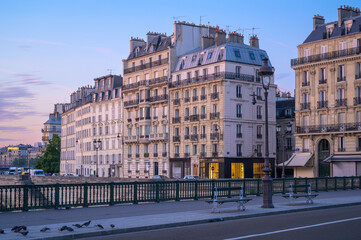 Parisian buildings along the riverside at twilight showcase elegant architecture and serene ambiance