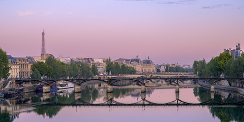 Sunrise over the Seine River in Paris, showcasing bridges and the Eiffel Tower