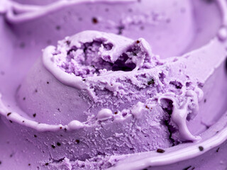Close-up of a scoop of purple blueberry ice cream. The ice cream appears to contain small, dark flecks and is partially melted.