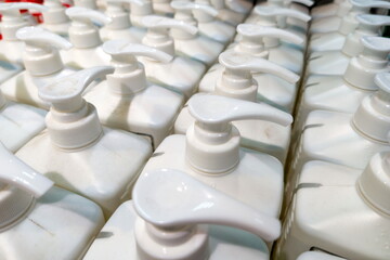 Obraz premium Rows of white dispensing bottles arranged neatly on a shelf in a retail store, showcasing various liquid products ready for customers