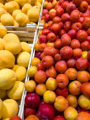 Freshly harvested yellow lemons and colorful apples stacked in a local market during a sunny afternoon in the summer season