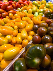 Colorful variety of heirloom tomatoes displayed at a farmers market during a sunny afternoon in late summer