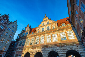 Fototapeta premium Gdansk, the Green Gate in a city on the Baltic coast of northern Poland, Europe. Low-angle view of historic architecture. Warm light bathes detailed facades.