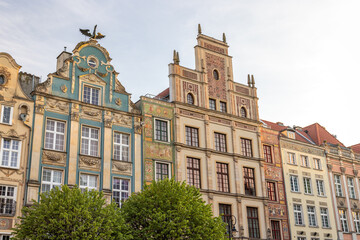 Obraz premium Gdansk, a city on the Baltic coast of northern Poland, Europe. Row of colorful historic buildings with decorative facades, intricate details, and ornate architectural styles under a bright sky.