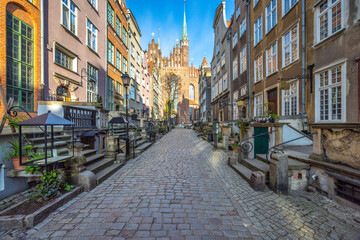Obraz premium Mariacka street in Gdansk city on the Baltic coast of northern Poland, Europe. Historical street with charming architecture and a cathedral, evoking a sense of old-world charm and cultural richness.
