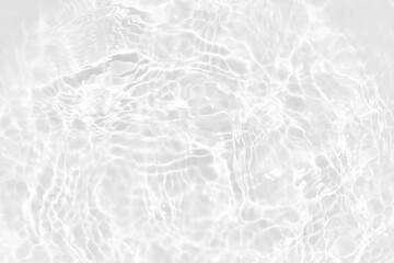 White water with ripples on the surface. Defocus blurred transparent white colored clear calm water surface texture with splashes and bubbles. Water waves with shining pattern texture background.